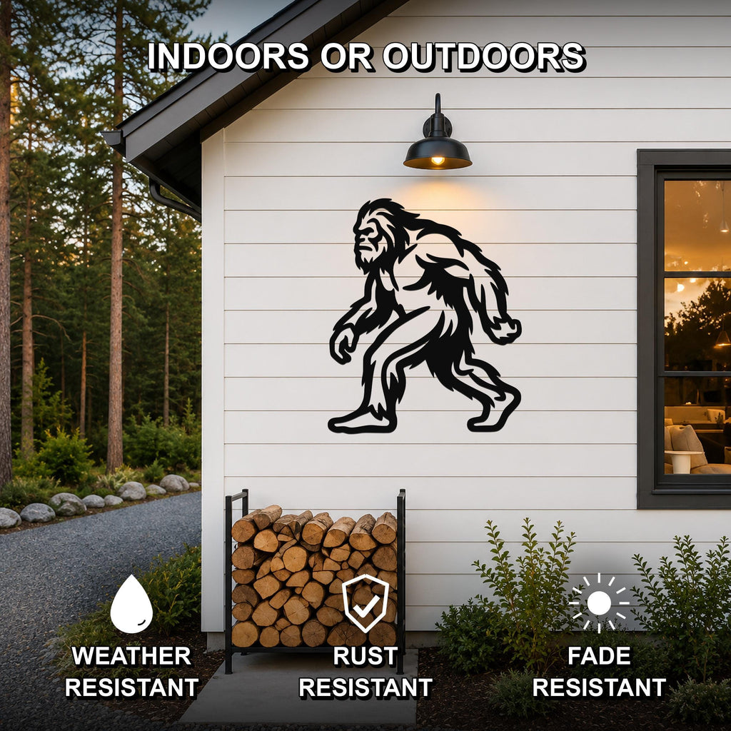 Black metal Bigfoot wall art silhouette mounted on a white siding exterior wall above a firewood rack, with text indicating it is weather, rust, and fade resistant for indoor or outdoor use.