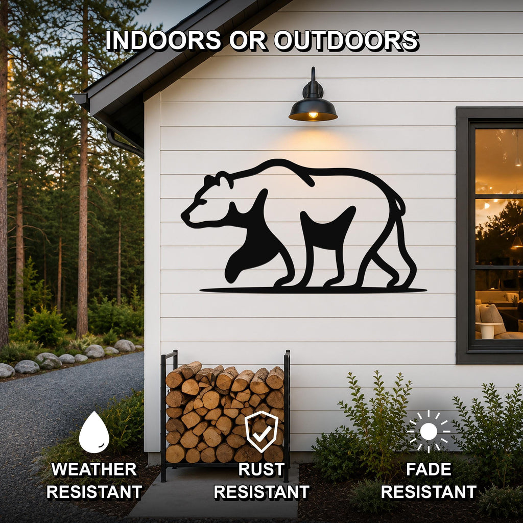 Black metal bear silhouette wall art mounted on a white siding exterior wall above a firewood rack, with text indicating it is weather, rust, and fade resistant for indoor or outdoor use.