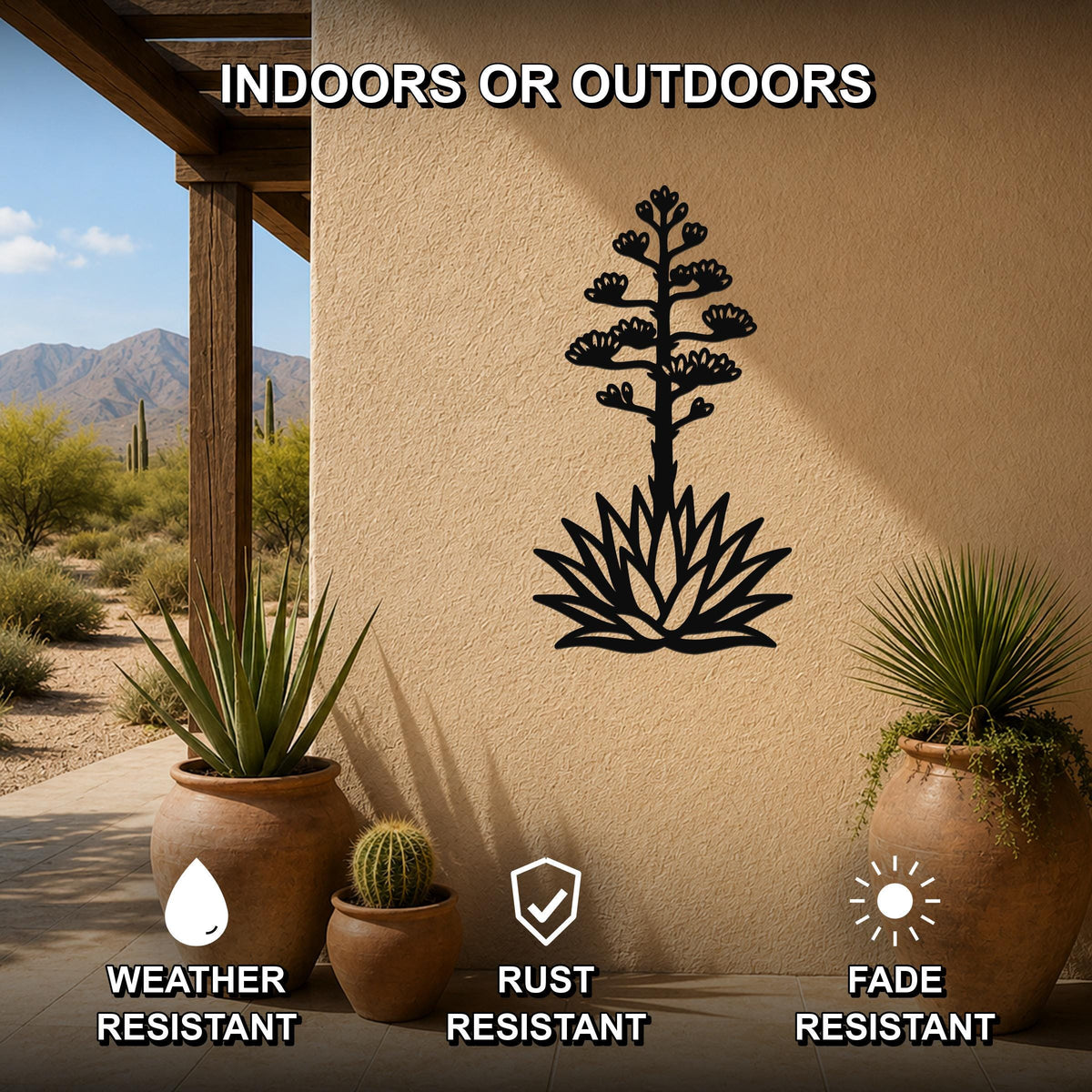 Black metal agave wall sculpture with blooming flower and spiky leaves cutout, mounted on a beige outdoor wall beside potted plants on a patio.