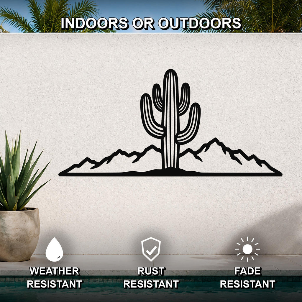 Black metal wall art featuring a saguaro cactus and mountain silhouette, mounted on an outdoor wall above a pool with a potted plant nearby.