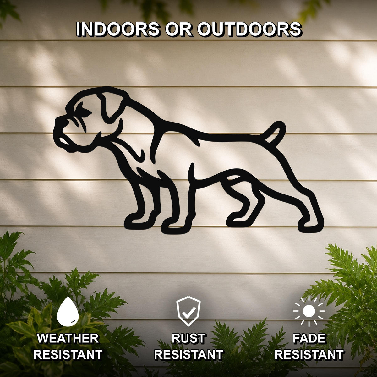Black metal Boxer dog silhouette wall art mounted on a light-colored outdoor wall, weather resistant, rust resistant, and fade resistant, with green foliage visible at the bottom.