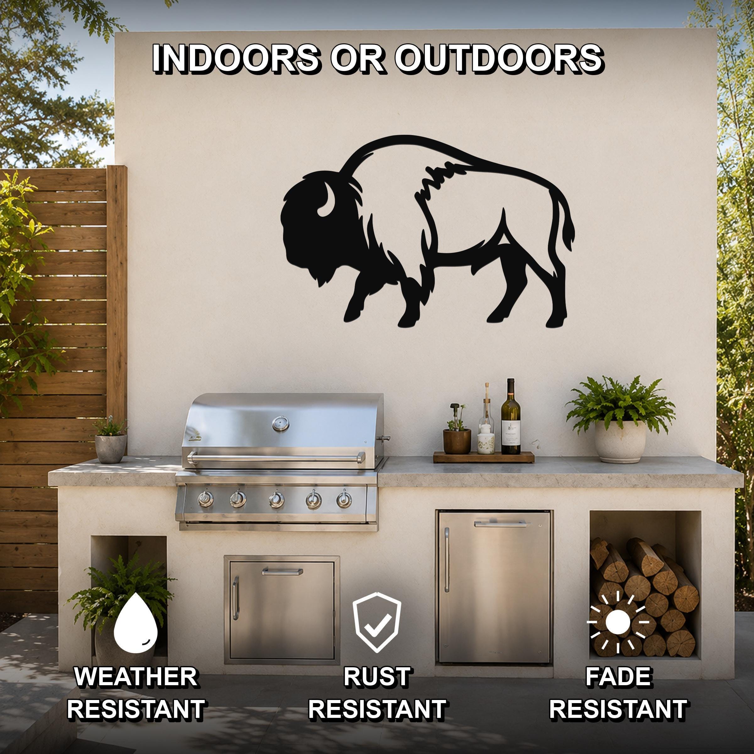 Black metal buffalo wall art silhouette mounted on an outdoor patio wall above a stainless steel grill and counter.