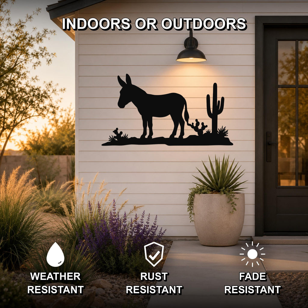 Black metal wall art featuring a burro silhouette with cacti, mounted on a white siding exterior wall above a patio, weather resistant, rust resistant, and fade resistant.