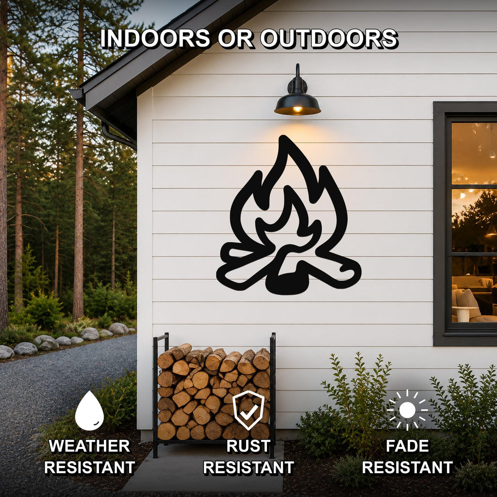 Black metal campfire silhouette wall art mounted on a white siding exterior wall above a firewood rack, with text indicating it is weather, rust, and fade resistant for indoor or outdoor use.