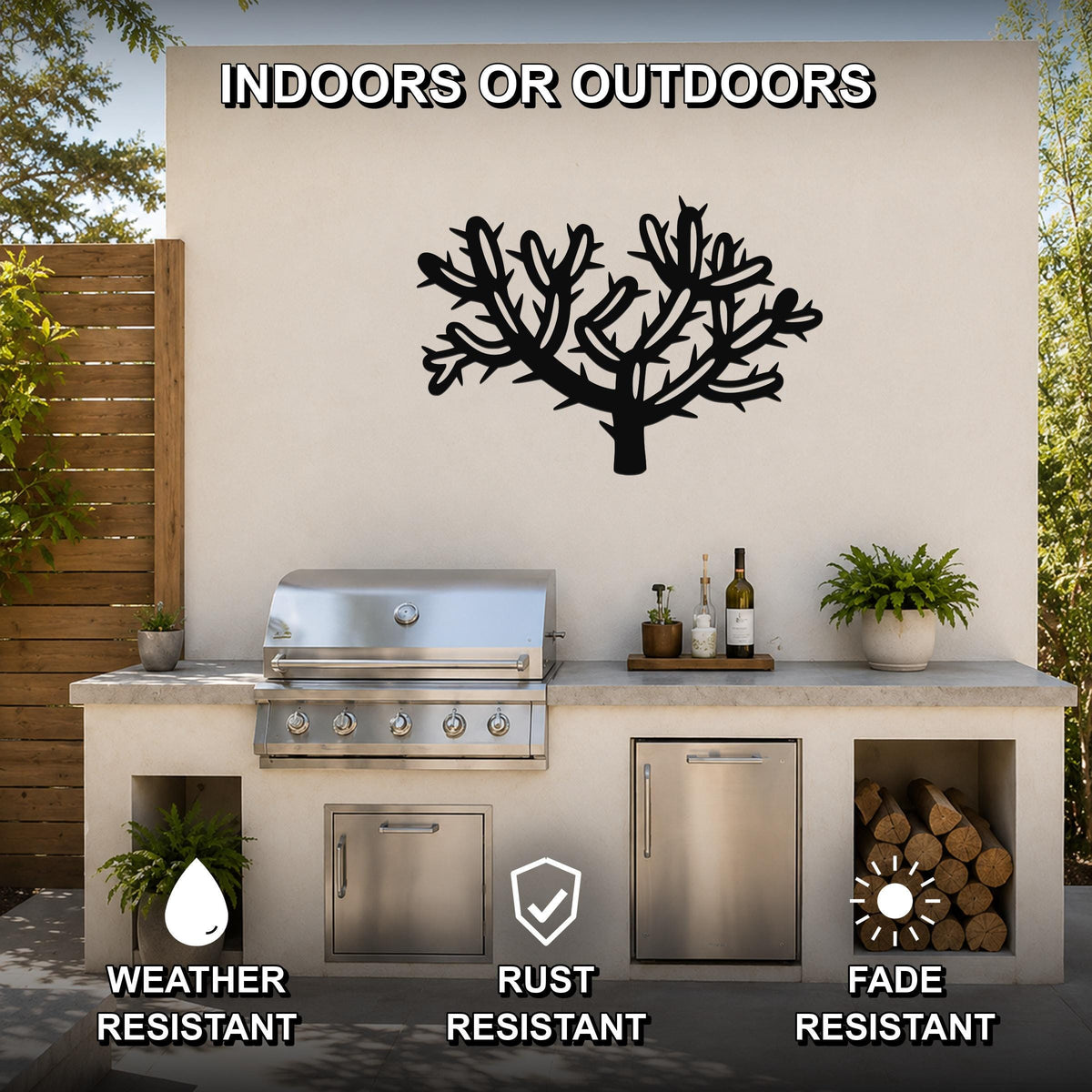 Black metal cholla cactus wall art with branching cutouts, mounted on an outdoor kitchen wall above a stainless steel grill.