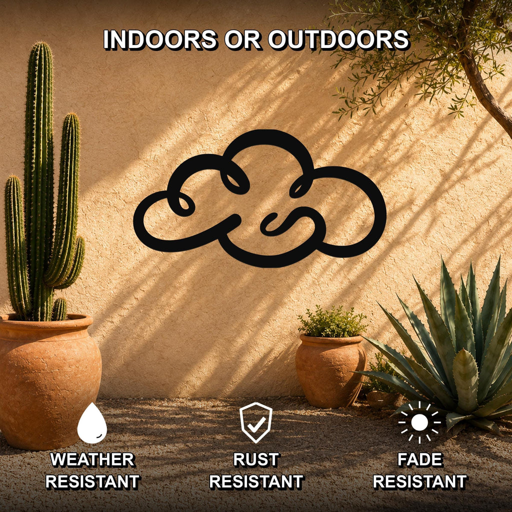 Black metal cloud wall art with a cutout silhouette, mounted on a stucco outdoor wall among potted cacti and succulents.