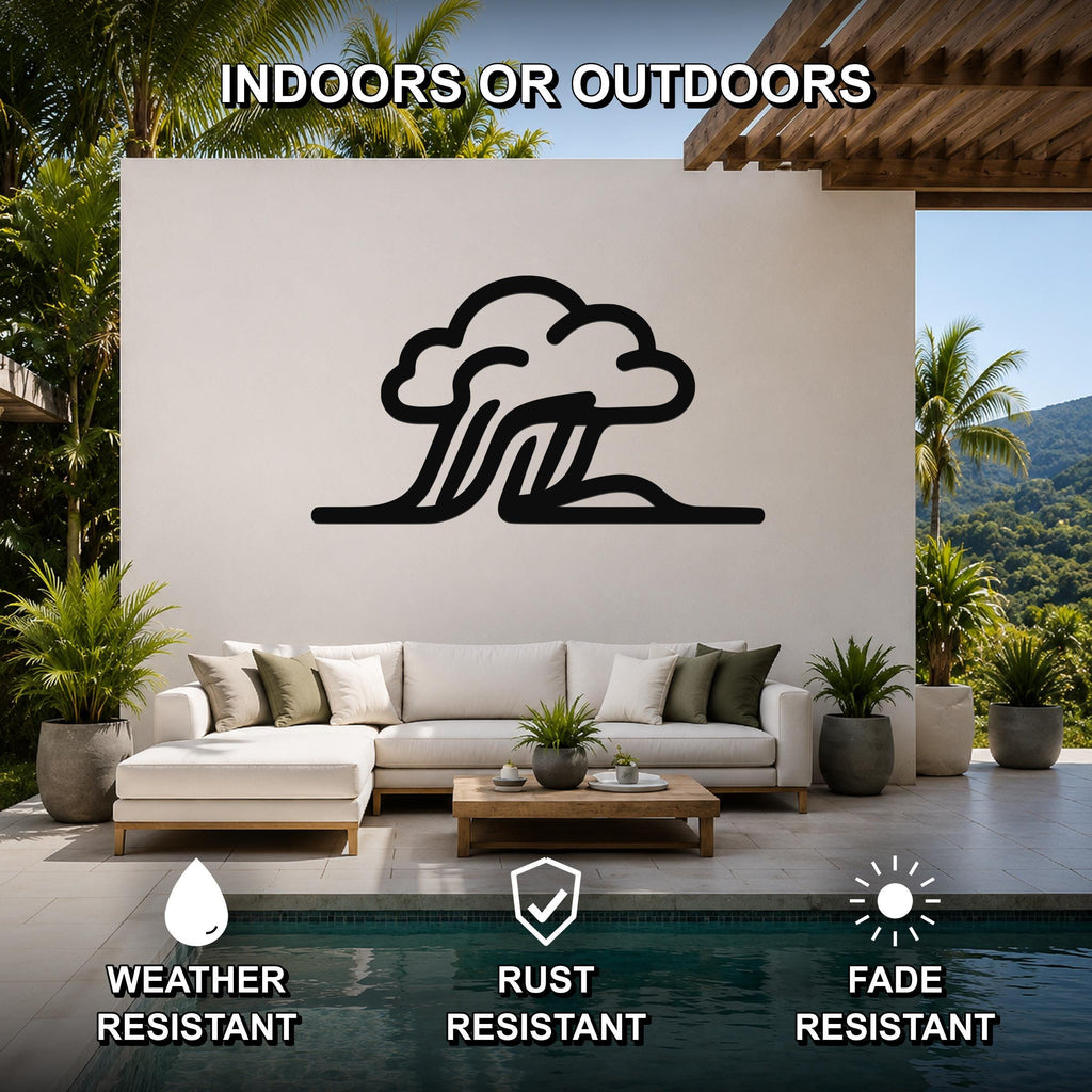 Black metal cloud and wave silhouette wall art mounted on a white outdoor wall above a white sectional sofa in a patio living area.