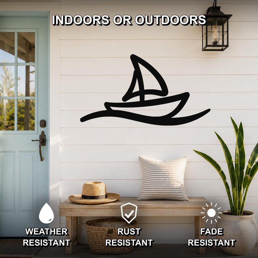 Black metal sailboat wall art with wave cutout, mounted on a white shiplap wall above a wooden bench on a porch.