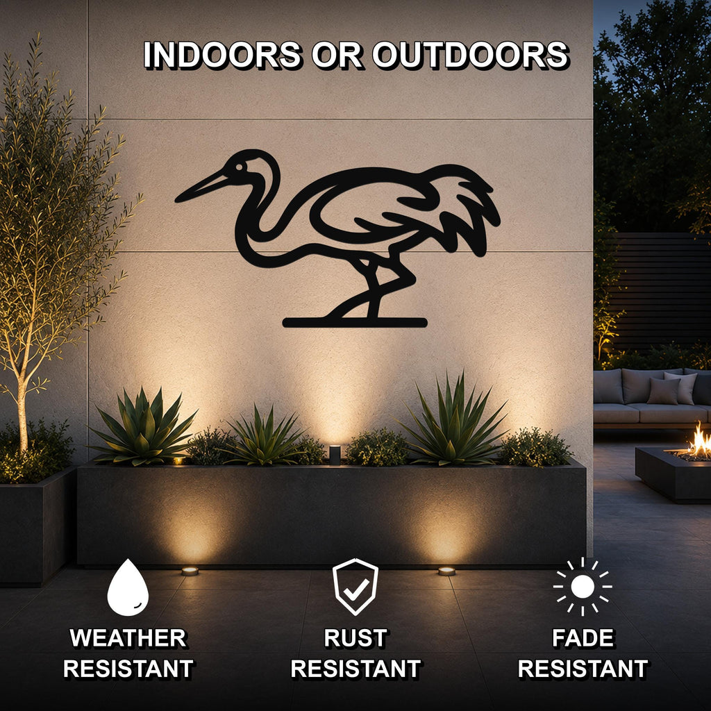 Black metal crane wall art silhouette mounted on an outdoor wall above a planter, with text indicating it is weather, rust, and fade resistant.