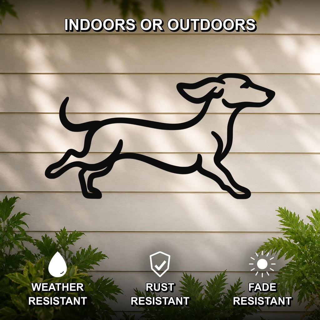 Black metal dachshund wall art in a running silhouette, mounted on a light-colored outdoor wall with greenery, weather resistant, rust resistant, and fade resistant.