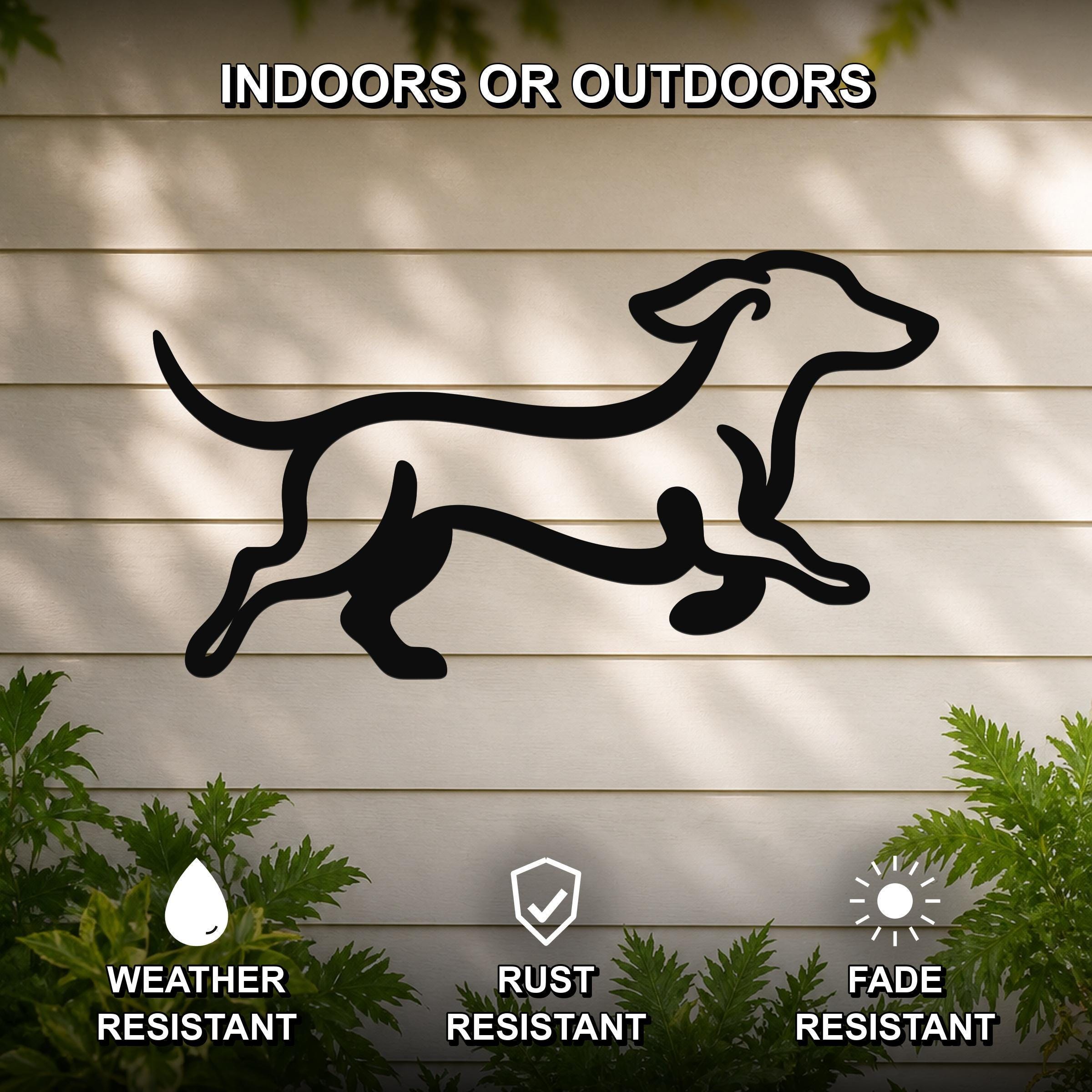 Black metal dachshund wall art with motion-line cutouts, mounted on a light-colored outdoor wall with greenery below.