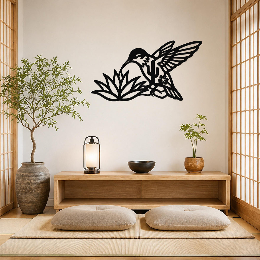 Black metal hummingbird wall art with floral and leaf cutouts, mounted on a wall above a wooden console in a minimalist room.