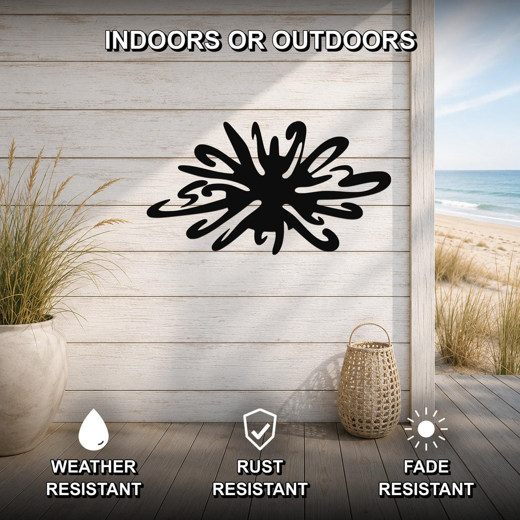 Black metal sea urchin wall art with organic spines cutout, mounted on a light wood plank wall above a wooden deck with a beach view.