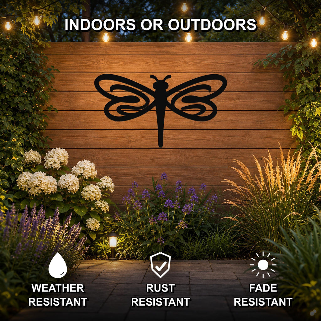 Black metal dragonfly wall art with intricate wing cutouts, mounted on a wooden outdoor wall surrounded by plants and string lights.
