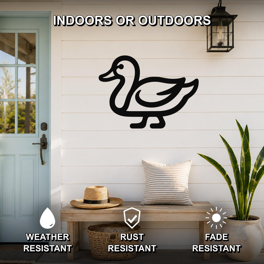 Black metal duck wall art silhouette mounted on a white shiplap wall above a wooden bench in a porch setting.