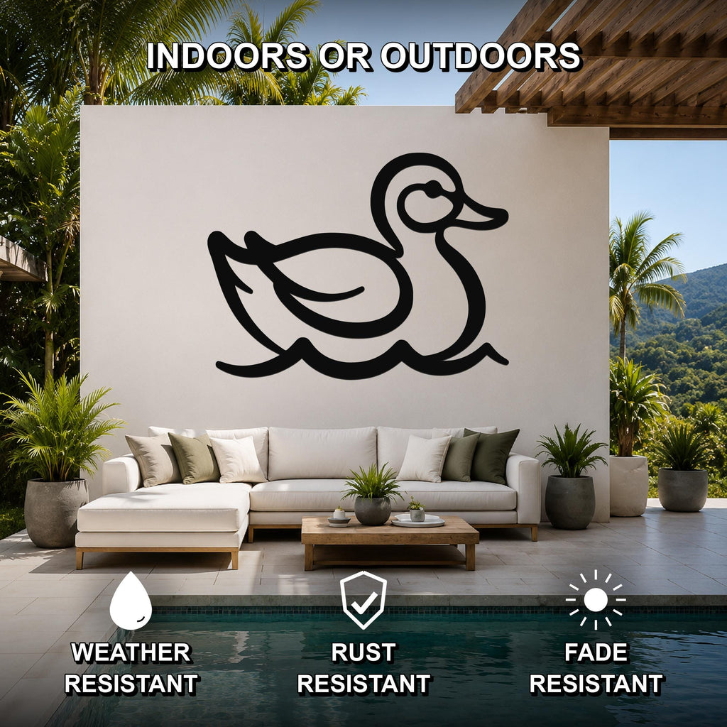 Black metal duck wall art silhouette with water wave cutouts, mounted on a white outdoor wall above a sofa in a patio living area.