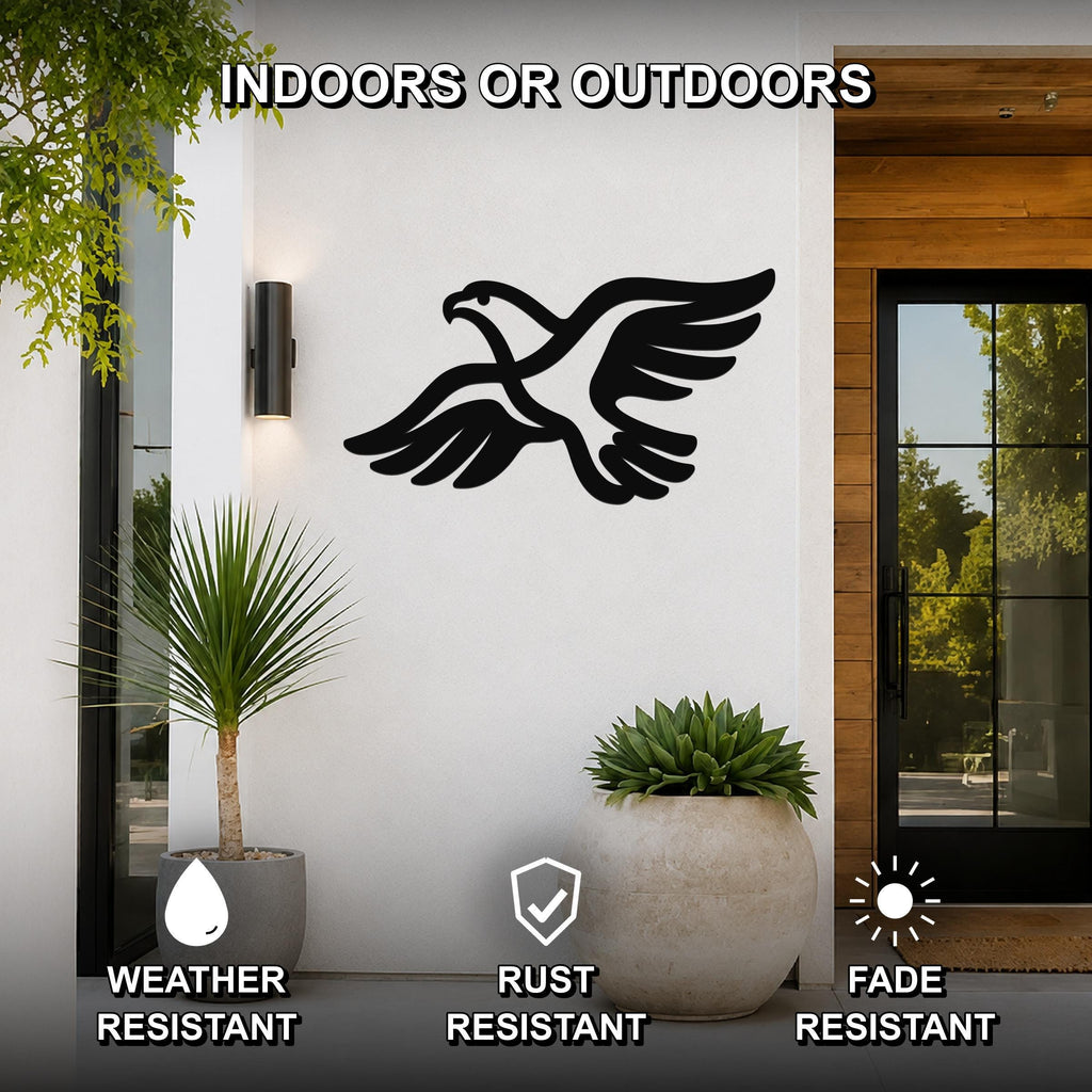 Black metal eagle wall art with outstretched wings and detailed feather cutouts, mounted on a white exterior wall above potted plants near a glass door.