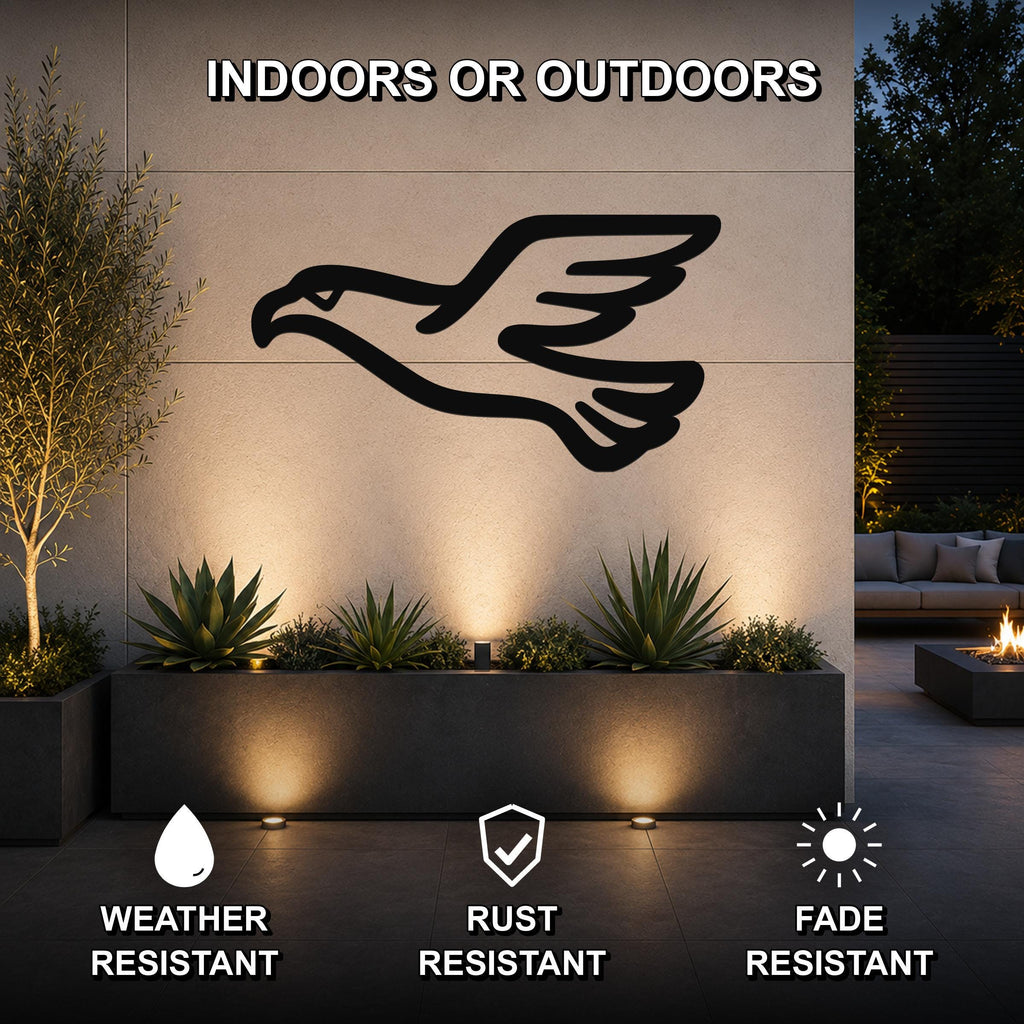 Black metal eagle wall art silhouette mounted on an outdoor wall above a planter, with warm uplighting and text indicating it is weather, rust, and fade resistant for indoor or outdoor use.