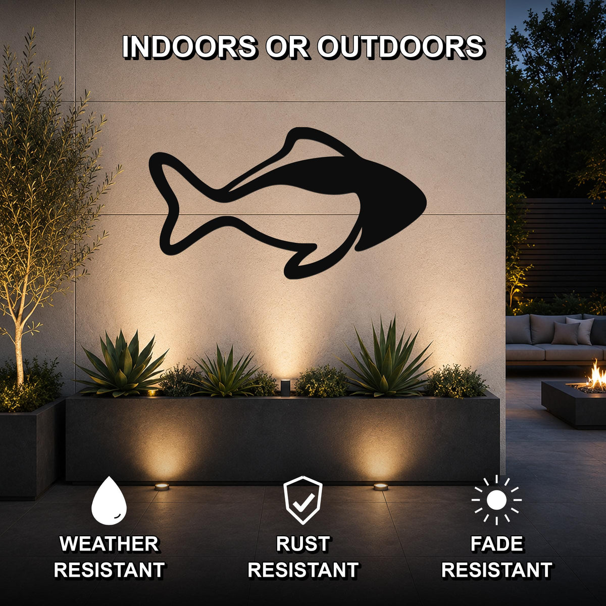Black metal fish silhouette wall art mounted on an outdoor wall above a planter, with text indicating it is weather, rust, and fade resistant for indoor or outdoor use.