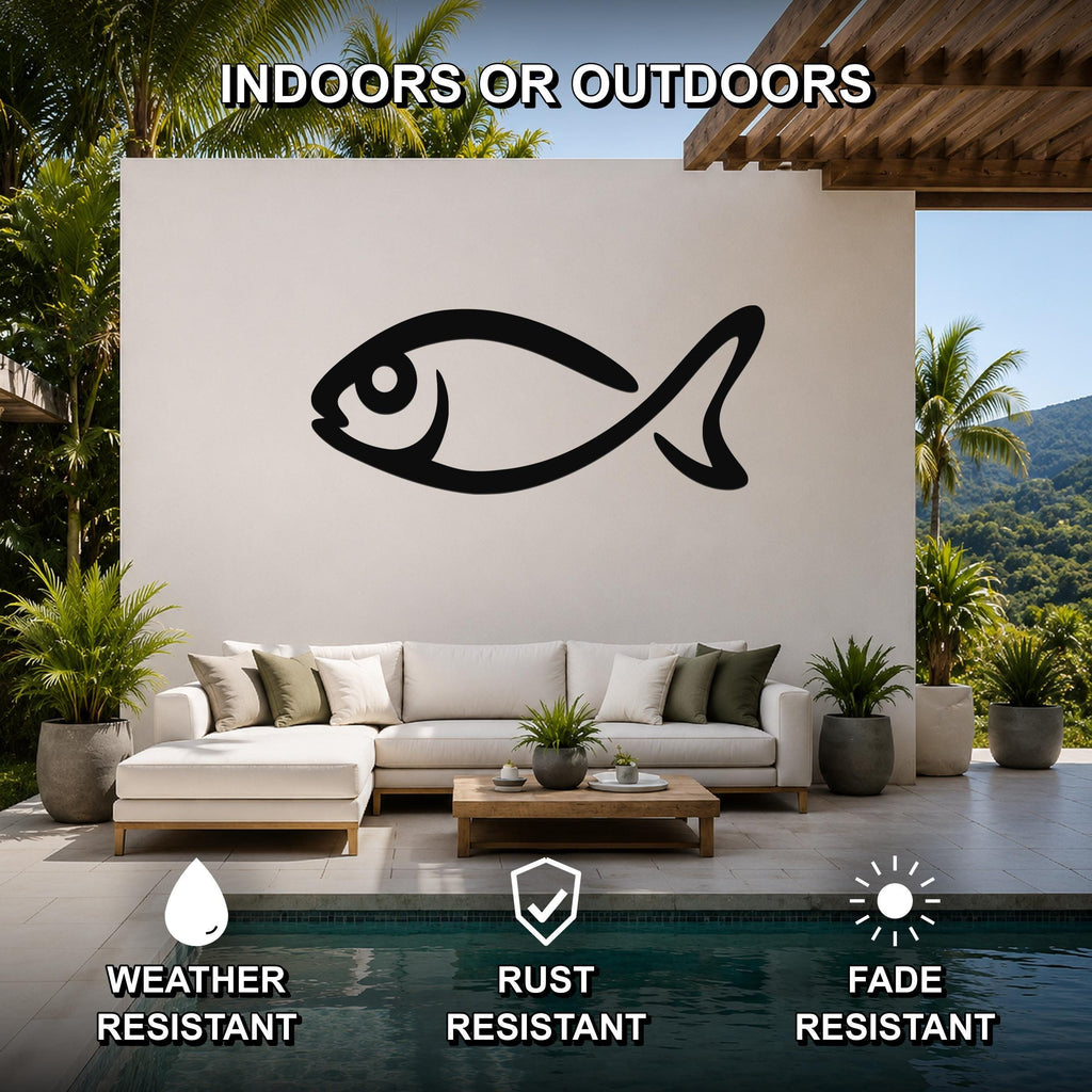 Black metal fish silhouette wall art mounted on a white outdoor wall above a white sofa in a patio living area.