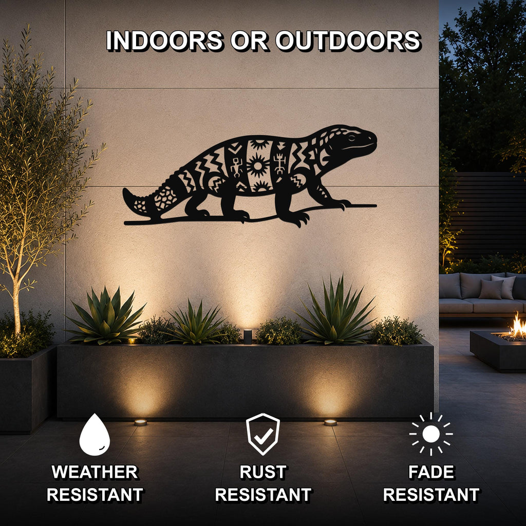 Black metal Gila monster wall art with intricate geometric cutouts, mounted on an outdoor wall above a planter in a modern patio setting.