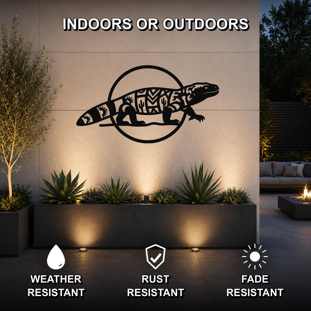 Black metal Gila monster wall art with geometric and cactus cutouts, mounted on an outdoor wall above a planter in a patio setting.
