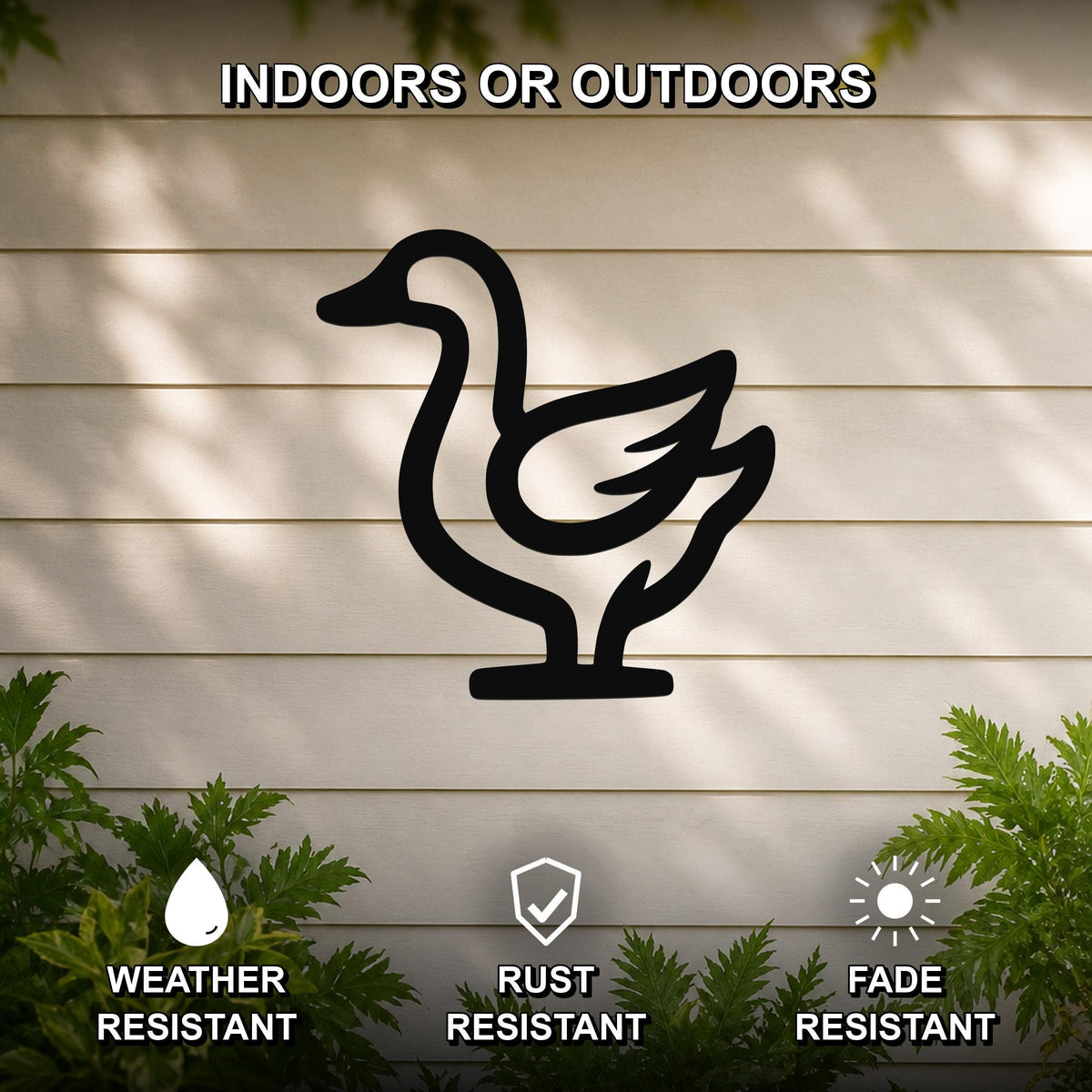 Black metal goose silhouette wall art mounted on a beige horizontal siding wall, with green foliage at the bottom and text indicating it is weather, rust, and fade resistant for indoor or outdoor use.