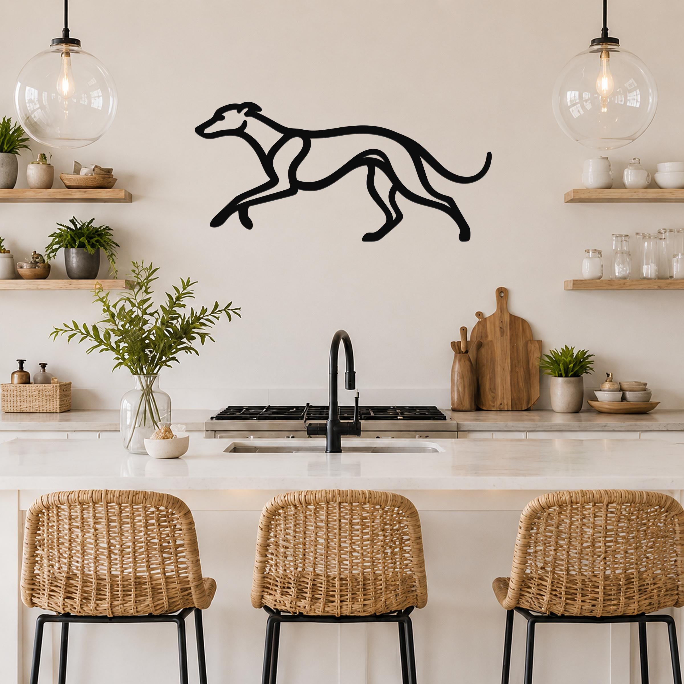 Black metal greyhound wall art with a sleek silhouette design, mounted on a kitchen wall above a counter with open shelving and pendant lights.