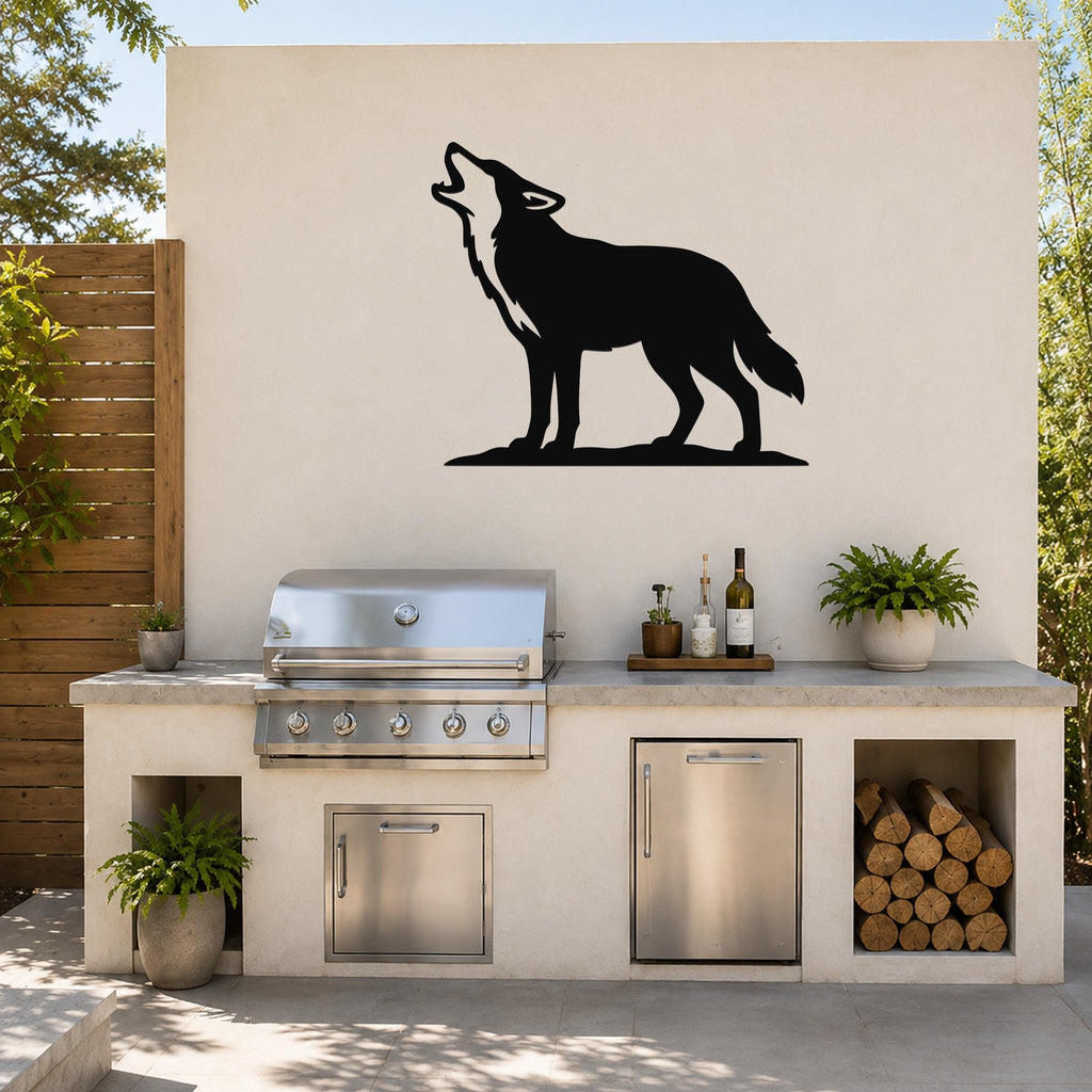 Black metal coyote wall art in a howling silhouette, mounted on an outdoor kitchen wall above a stainless steel grill and counter.