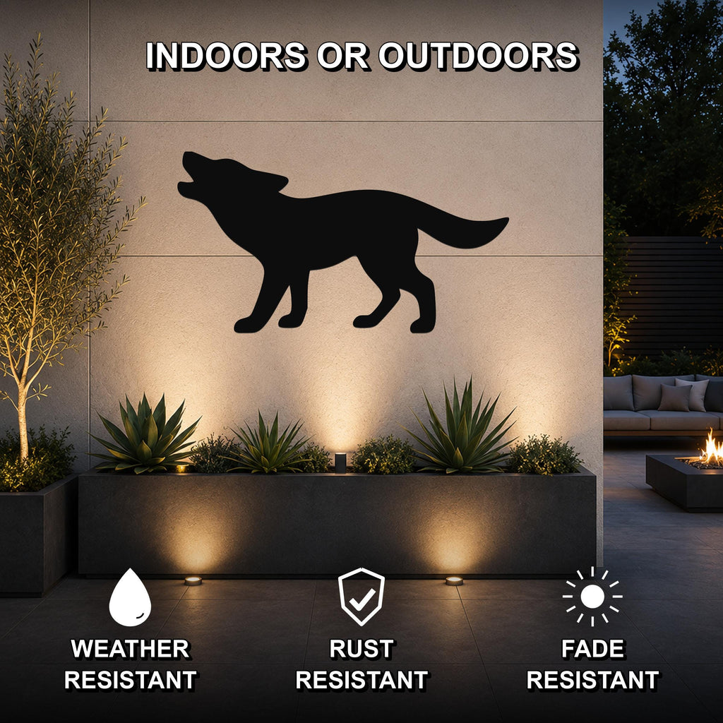 Black metal coyote silhouette wall art mounted on an outdoor wall above a planter, shown in a patio setting with uplighting.