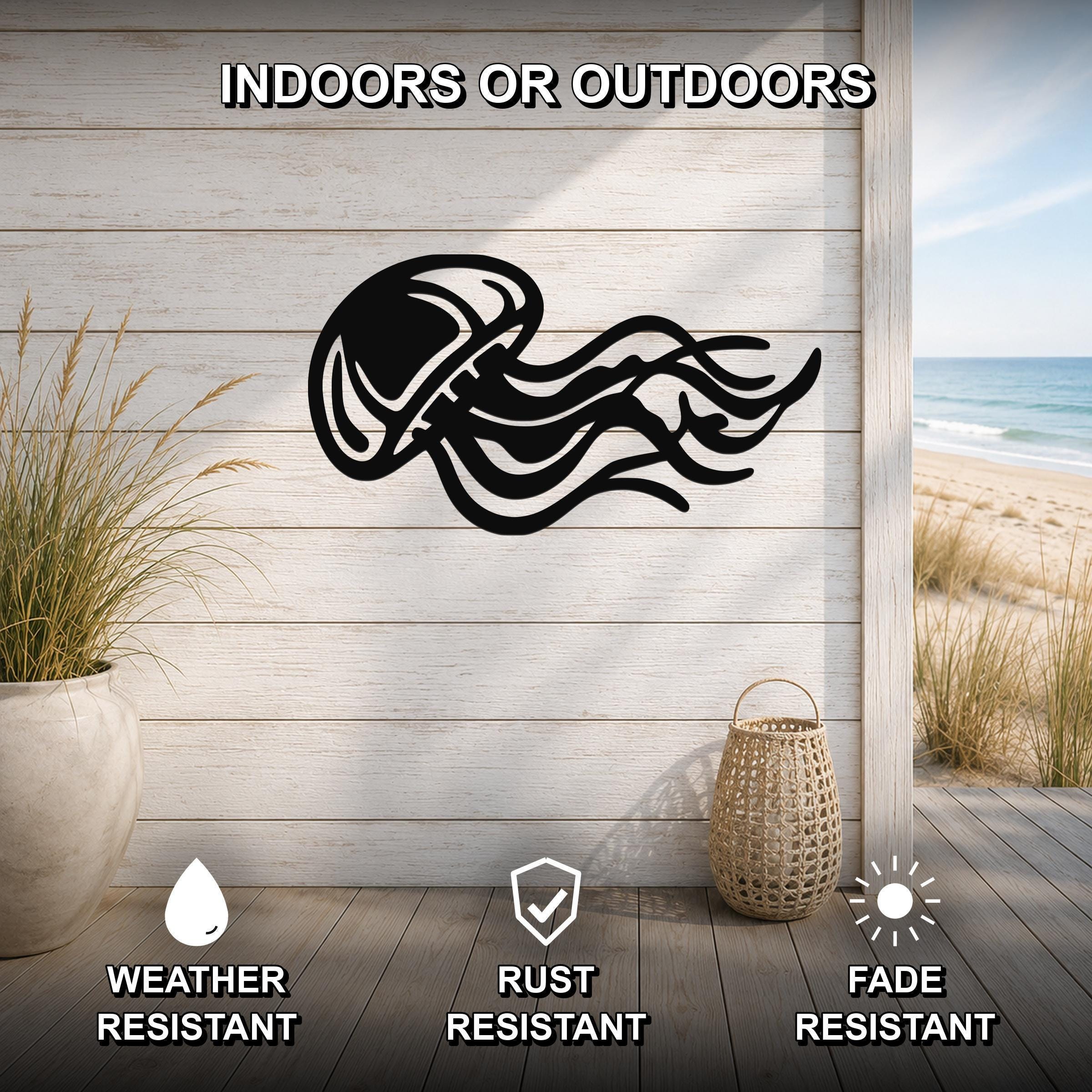 Black metal jellyfish wall art with flowing tentacle cutouts, mounted on a light wood plank wall in a coastal indoor-outdoor space.
