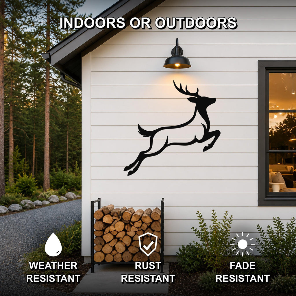 Black metal jumping deer wall art silhouette mounted on a white siding exterior wall above a firewood rack, with text indicating it is weather, rust, and fade resistant for indoor or outdoor use.