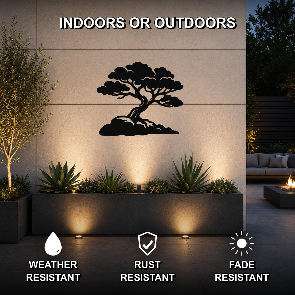 Black metal juniper tree wall art with a silhouette design, mounted on an outdoor wall above a planter in a modern patio setting.