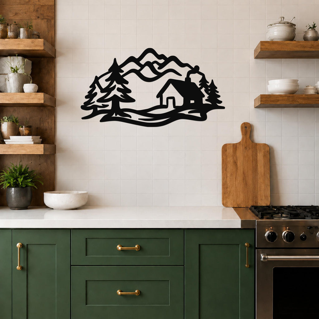 Black metal wall art with a mountain cabin silhouette, featuring trees and peaks, mounted on a tiled kitchen wall above a counter.