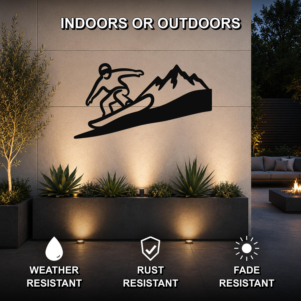 Black metal wall art featuring a snowboarder silhouette and mountain cutout, mounted on an outdoor wall above a planter in a modern patio setting.