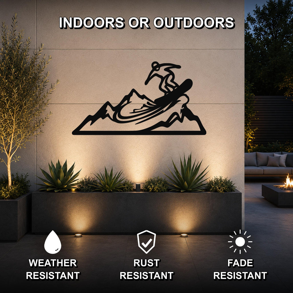 Black metal wall art featuring a snowboarder silhouette on a mountain, mounted on an outdoor wall above a planter in a patio setting.