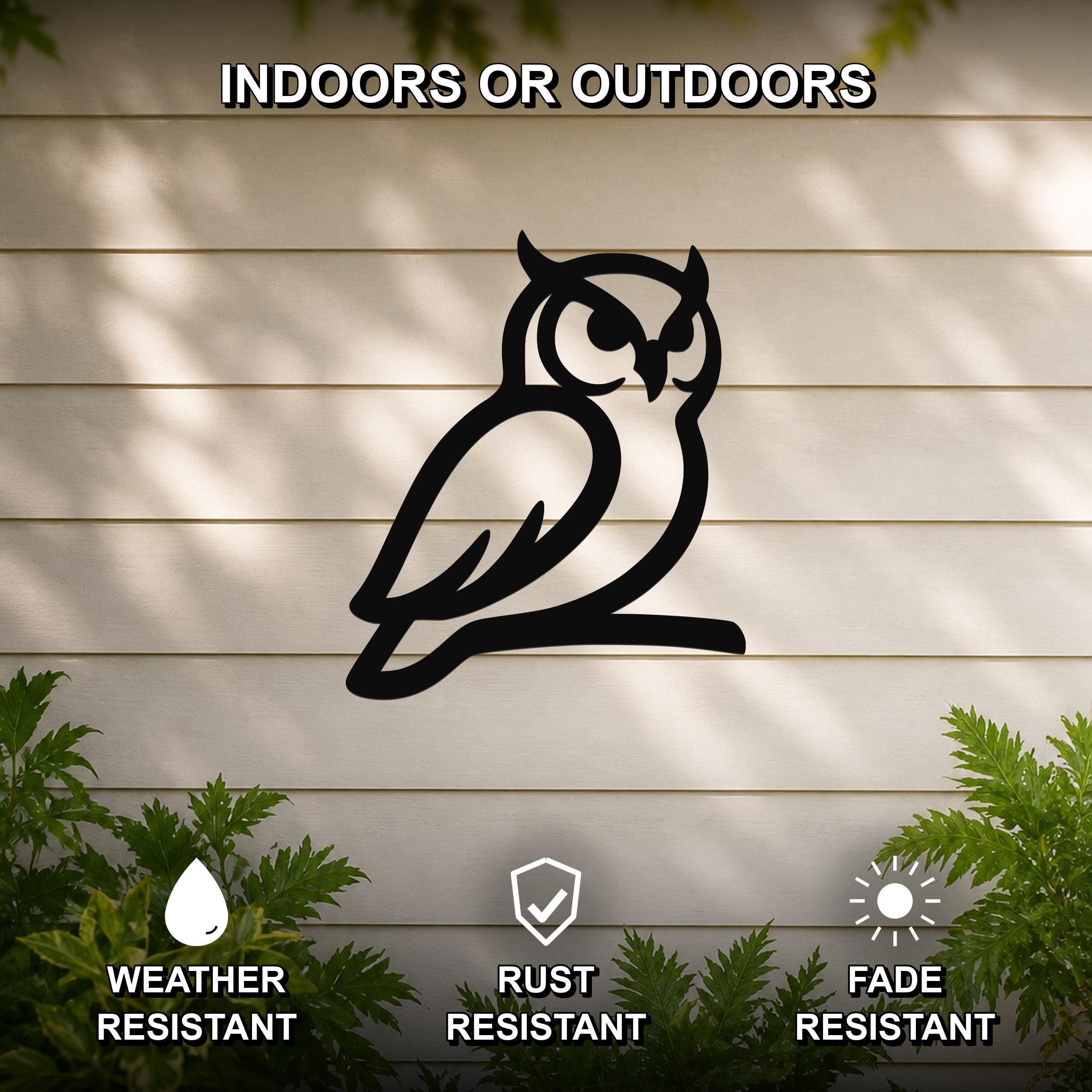 Black metal owl wall art silhouette mounted on a beige outdoor wall, with green plants at the base and text indicating it is weather, rust, and fade resistant.