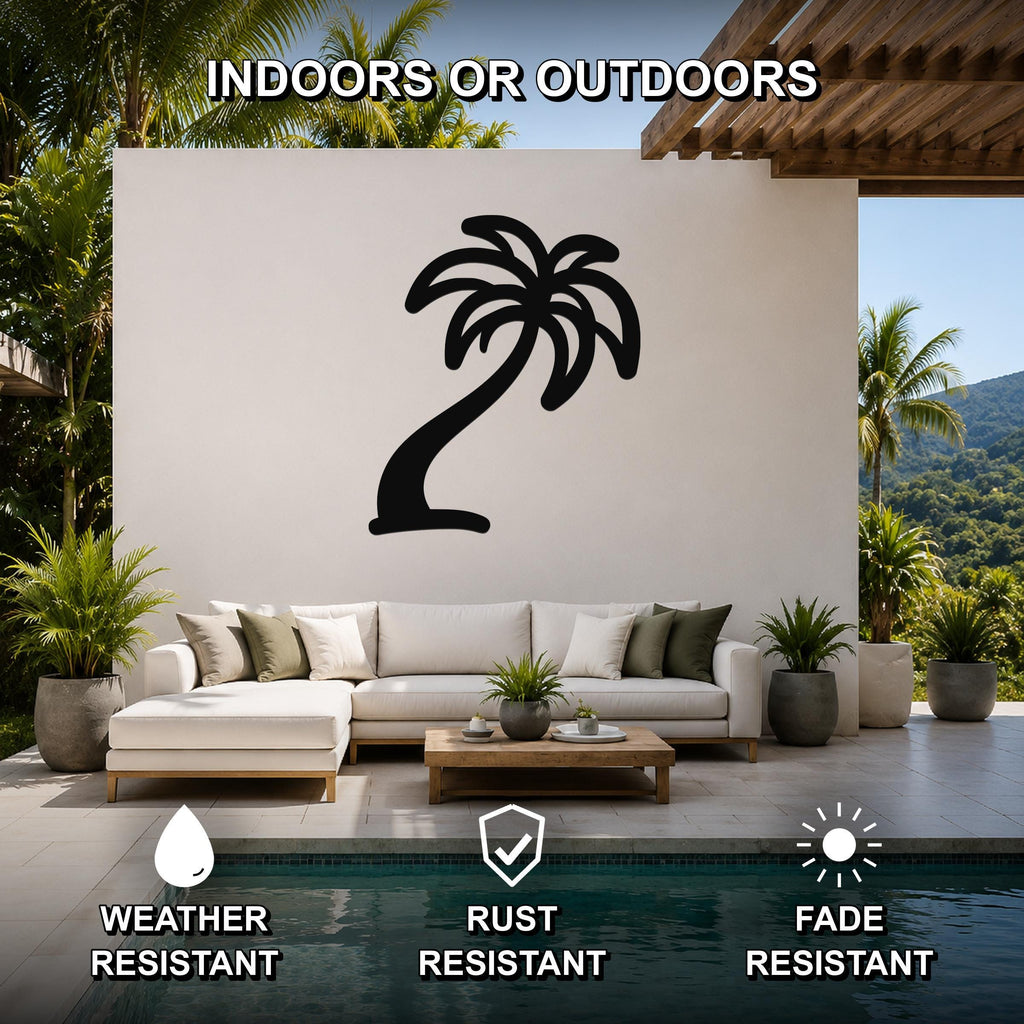 Black metal palm tree wall art silhouette mounted on a white outdoor wall above a white sectional sofa in a patio living area.