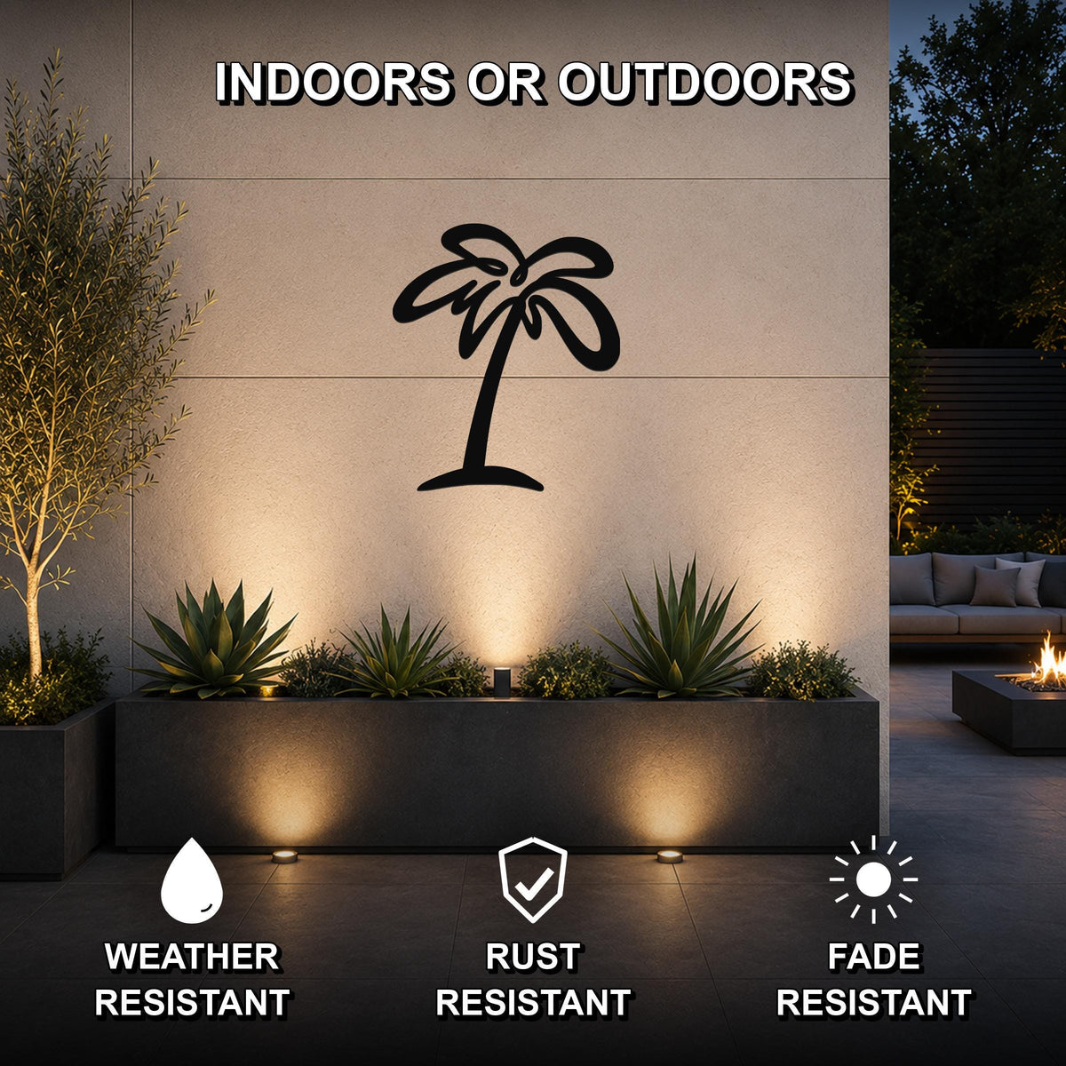 Black metal palm tree wall art silhouette mounted on an outdoor wall above a planter, illuminated by uplights in a patio setting.