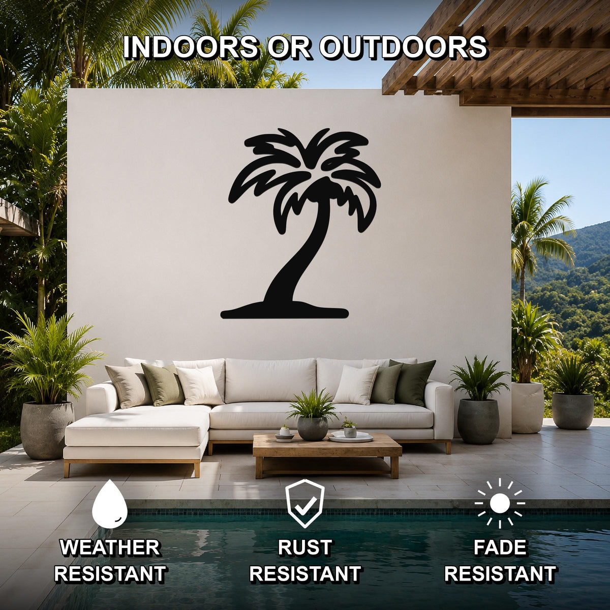 Black metal palm tree wall art silhouette mounted on a white outdoor wall above a white sectional sofa in a patio setting.
