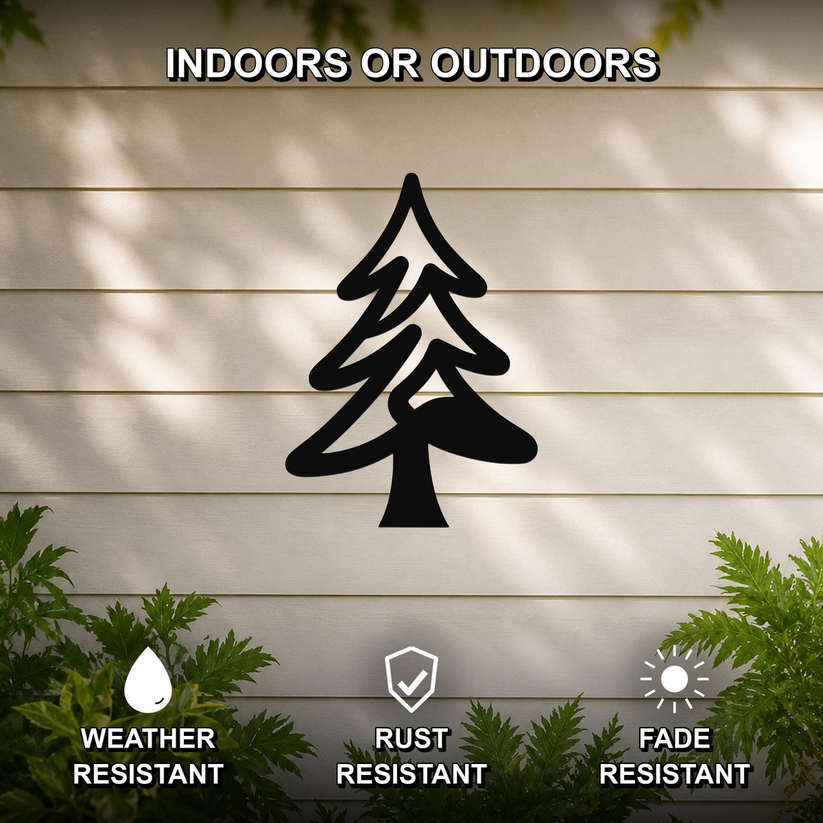 Black metal pine tree wall art silhouette mounted on a beige horizontal siding wall, with green foliage at the bottom, labeled as weather, rust, and fade resistant for indoor or outdoor use.