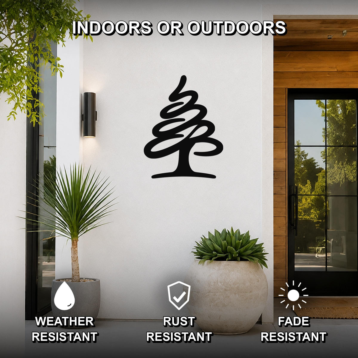 Black metal pine tree wall art silhouette mounted on a white exterior wall beside a glass door, with potted plants nearby and text indicating it is weather, rust, and fade resistant for indoor or outdoor use.