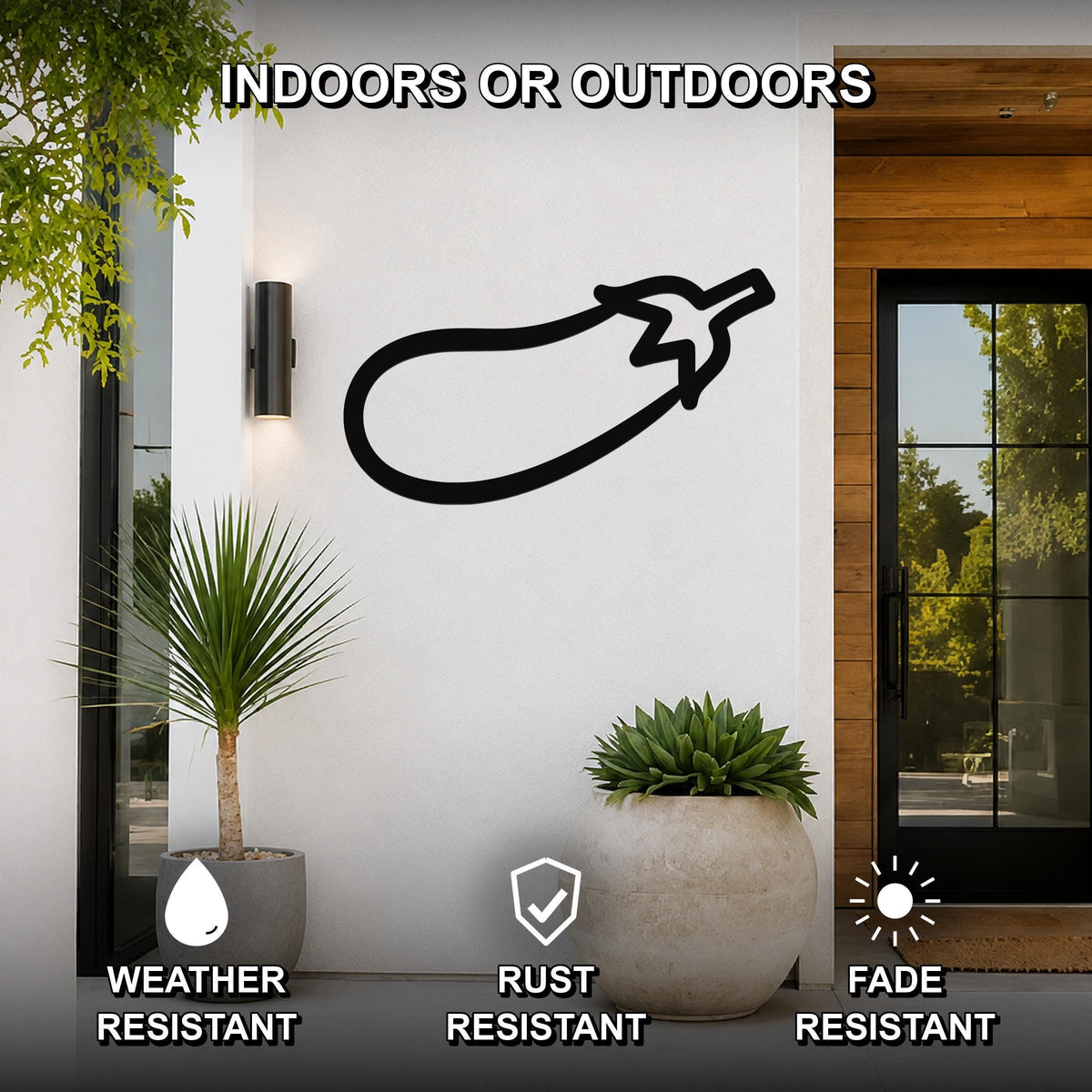 Black metal eggplant wall art silhouette mounted on a white exterior wall beside a glass door and potted plants, with text indicating it is weather, rust, and fade resistant.