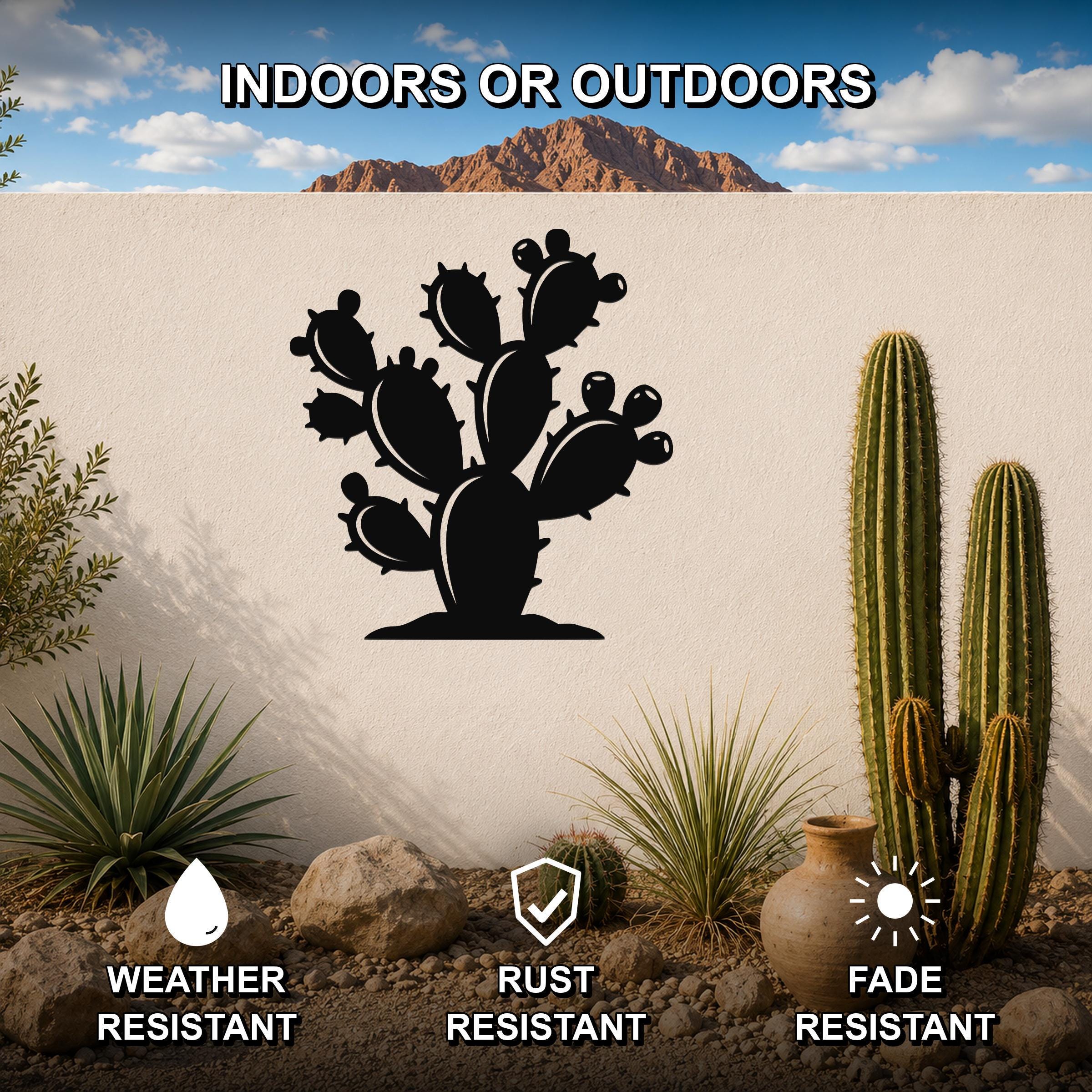 Black metal prickly pear cactus wall art with detailed cutout silhouette, mounted on an outdoor wall in a desert garden setting.