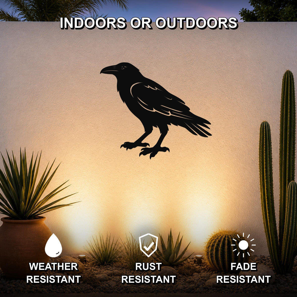 Black metal raven wall art silhouette mounted on an outdoor wall above a desert garden with cacti and succulents, weather, rust, and fade resistant.