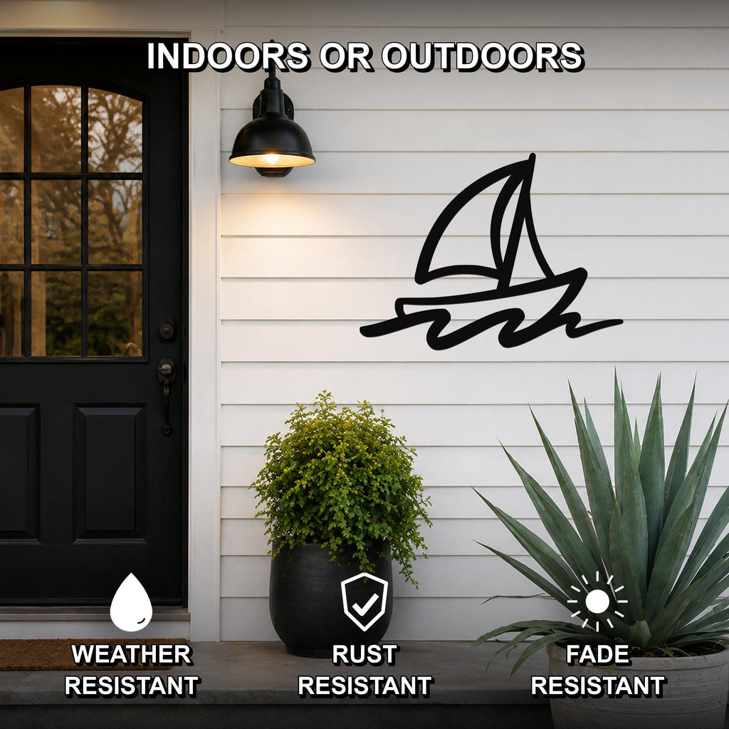 Black metal sailboat wall art with wave cutouts, mounted on a white exterior wall beside a front door.