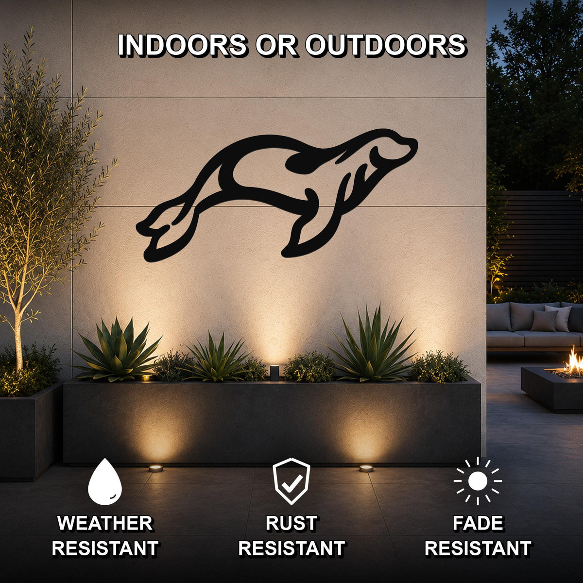 Black metal sea lion wall art with motion-line cutouts, mounted on an outdoor wall above a planter in a modern patio setting.