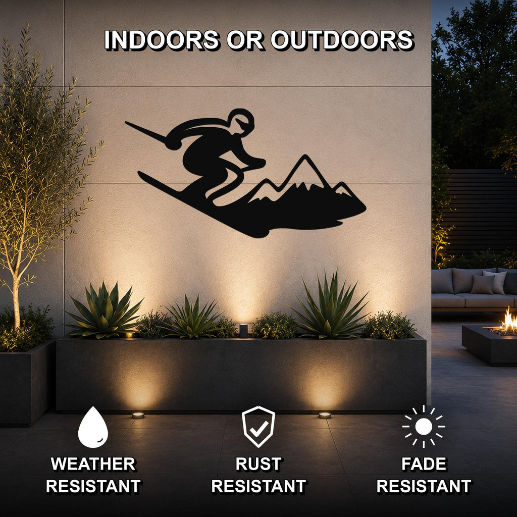 Black metal skier and mountain wall art silhouette mounted on an outdoor patio wall above a planter, with text indicating it is weather, rust, and fade resistant.