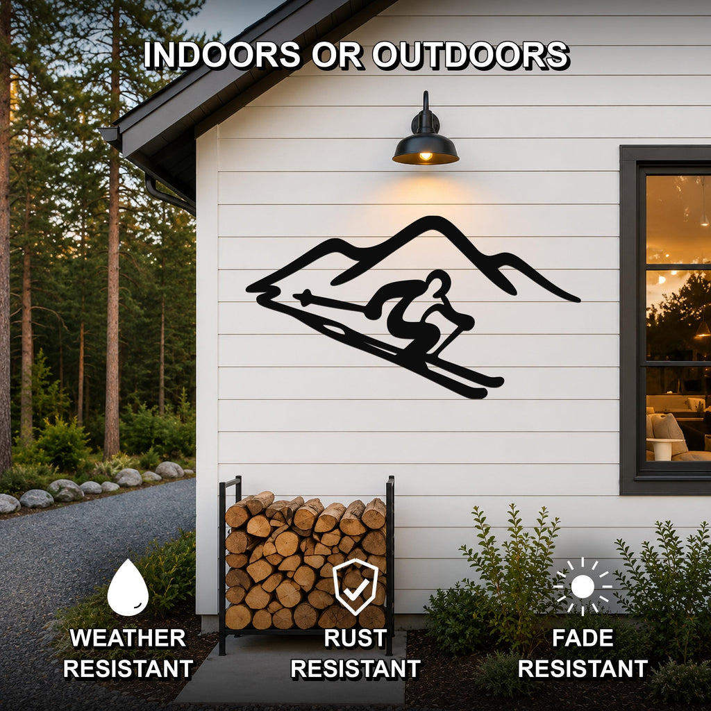 Black metal skier and mountain wall art silhouette mounted on a white exterior wall above a firewood rack, with text indicating it is weather, rust, and fade resistant for indoor or outdoor use.