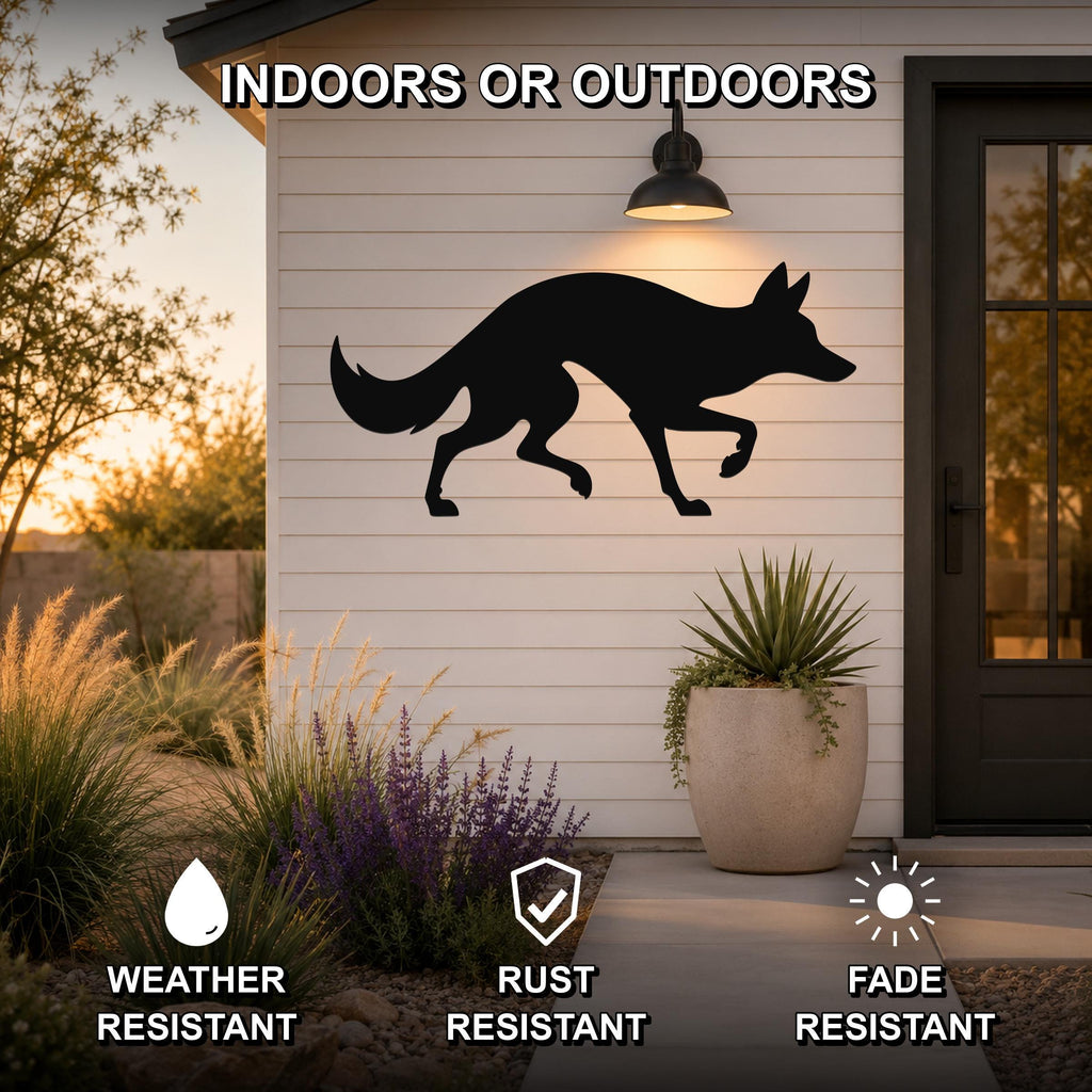 Black metal coyote silhouette wall art mounted on a white siding exterior wall above a patio, with a potted plant and garden in the foreground.